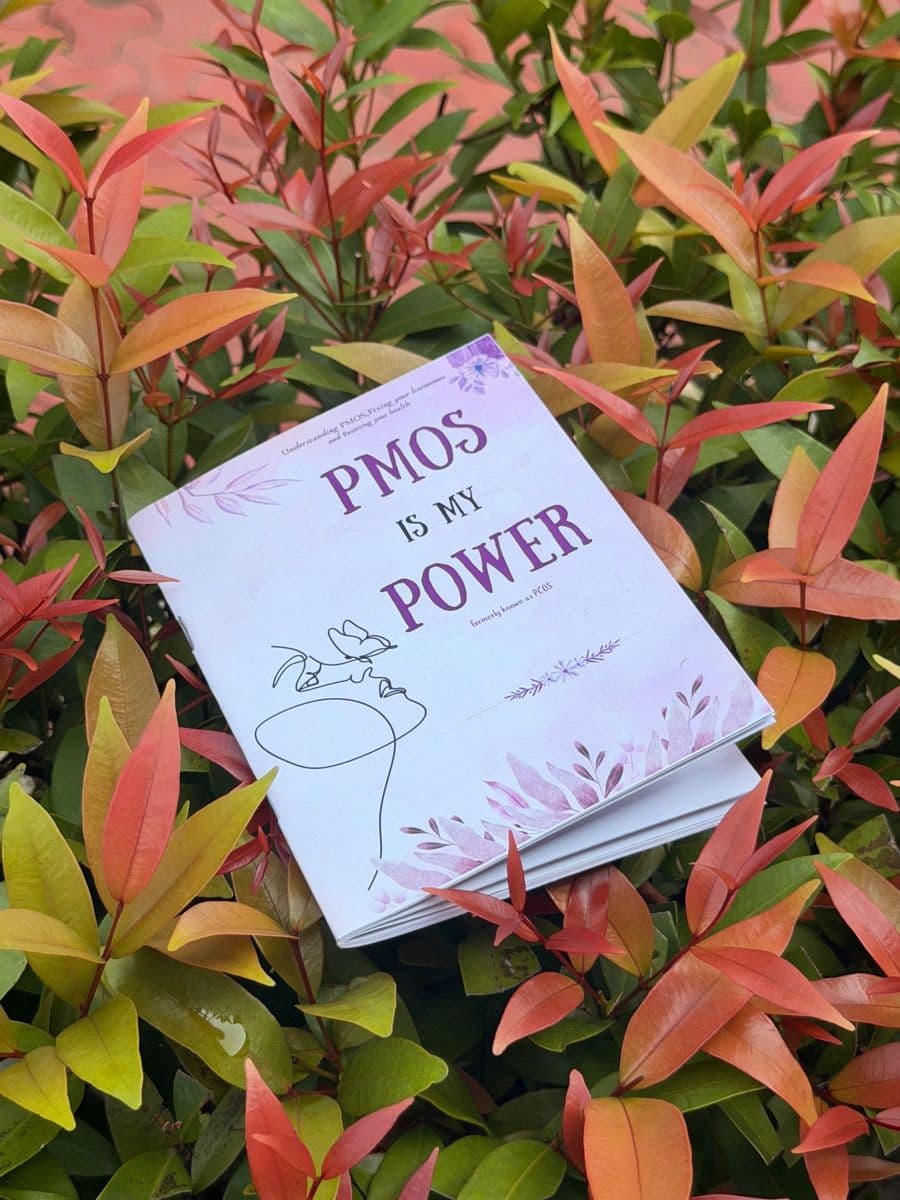 The booklet PMOS is My Power, lying on red-tipped leaves