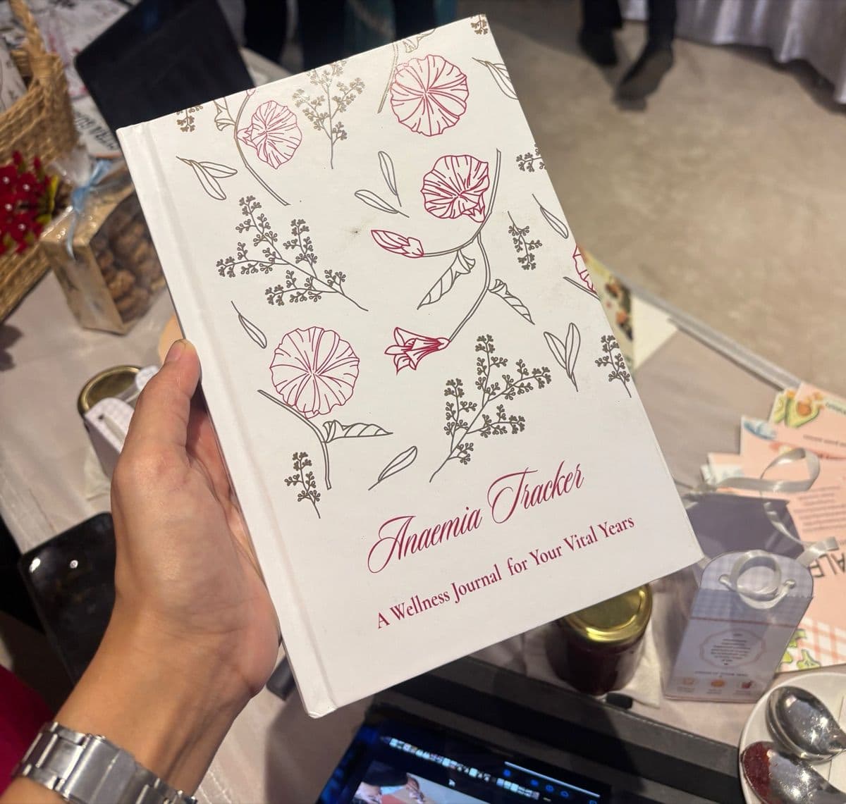 The hardcover Anaemia Tracker journal, held in one hand